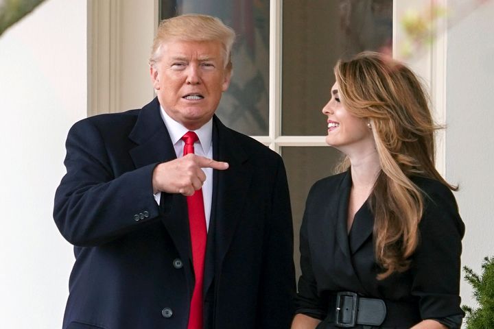 President Donald Trump points to outgoing White House communications director Hope Hicks on her last day before he boards Mar