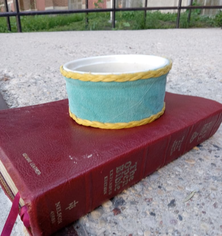 A smudge bowl is placed on top of a Bible. 