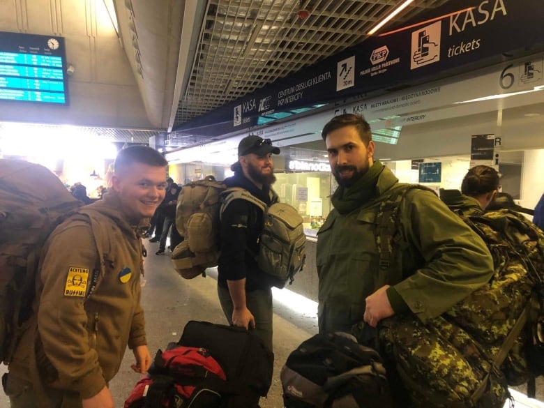 Three men dressed in army uniform are at an airport.