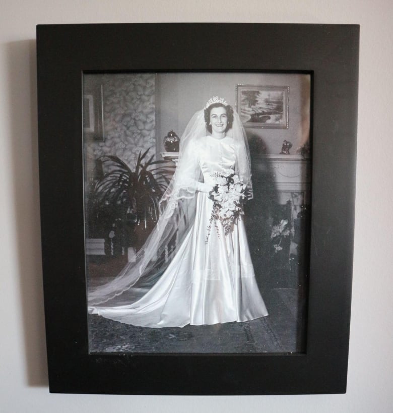 A framed black-and-white photograph shows a woman in a wedding dress and holding a bouquet