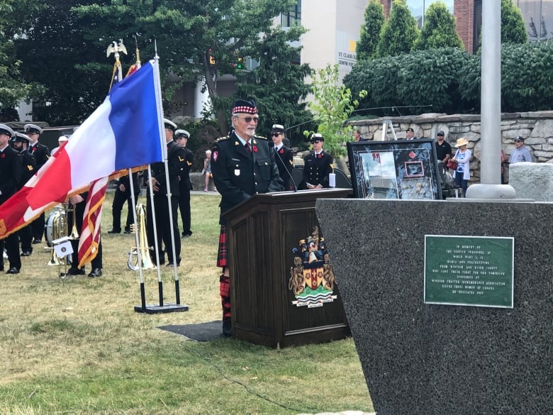 A soldiers delivers remembrance remarks at a podium.