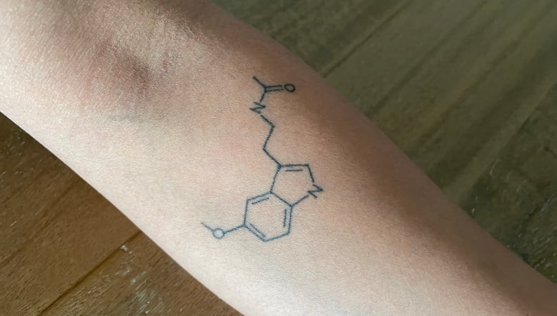 A tattoo of a chemical structure on a forearm.