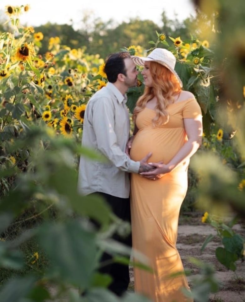 Two people looking at each other in a field of sunflowers. 