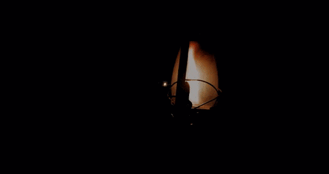 A lantern moves in the darkness.