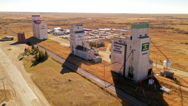 Three grain elevators overlooking prairie landscape