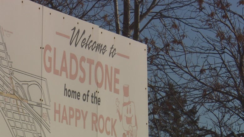 A sign that says. "Welcome to Gladstone, home of the Happy Rock."