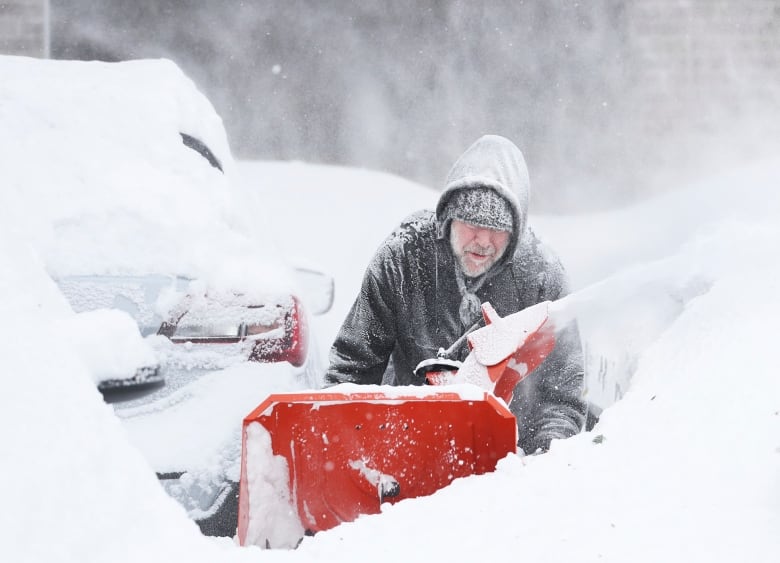 A man pushes a slow plow.
