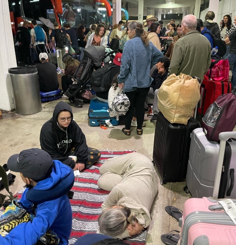 Les passagers sont vus alors qu'ils attendent leur transport à l'aéroport de Cancun, au Mexique, le jour de Noël. 