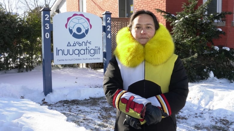 Stephanie Mikki Adams, executive director of Innuqatigit Centre for Inuit Children, Youth and Families, wearing a parka adorned with the yellow and white of the Nunavut territorial flag. Her cuffs also pay homage to the territorial flag with red inukshuks.