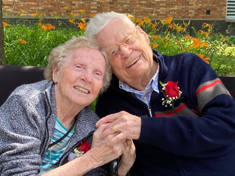 Gwen and John Hooper hold hands and lean on each other in photo taken to mark their 72nd wedding anniversary.