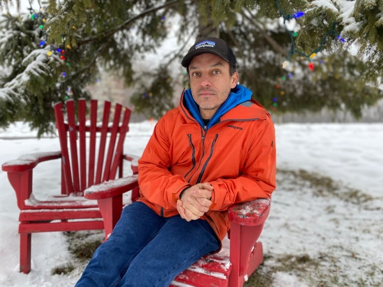 man sits in chair surrounded by snow