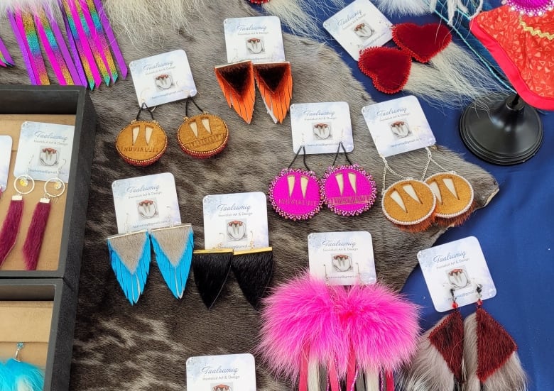 Colourful Indigenous-made earrings, which are for sale, sit on a table. 