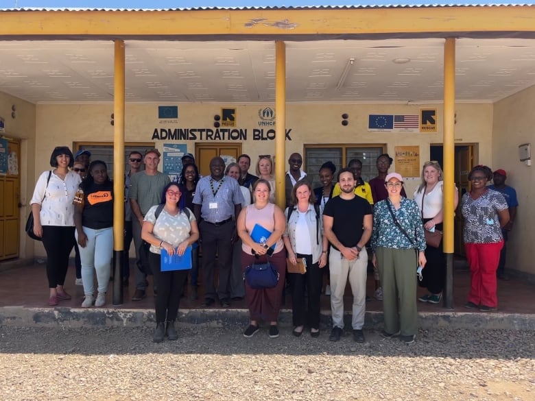 Nova Scotia representatives are shown among more than 20 people standing in front of an administration building at the Kakuma refugee camp in Kenya.