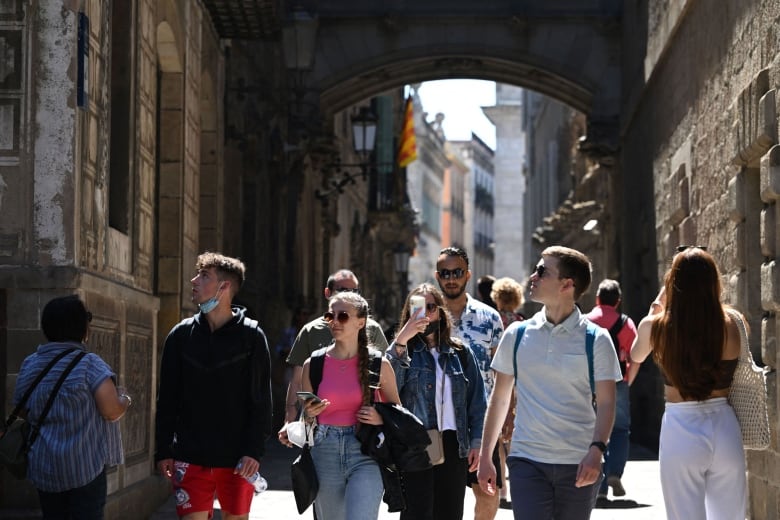 Tourists walk through Barcelona.