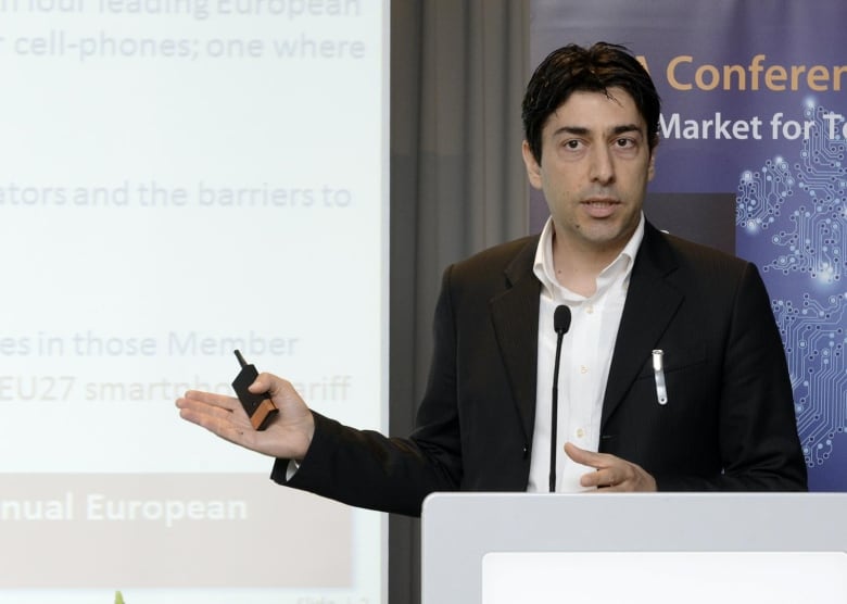 A man is presenting an unknown presentation at a podium. 