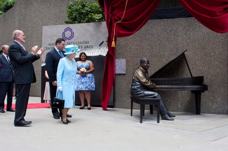 Queen Elizabeth takes part in the unveiling of a statue of Canadian jazz legend Oscar Peterson, with Minister of Canadian Heritage and Official Languages James Moore, second from left, and National Arts Centre President Peter Herrndorf, left, at the NAC in Ottawa on Wednesday June 30, 2010. Oscar Peterson's daughter Celine looks on at back. The royal couple is on a nine-day tour of Canada. THE CANADIAN PRESS/Sean Kilpatrick