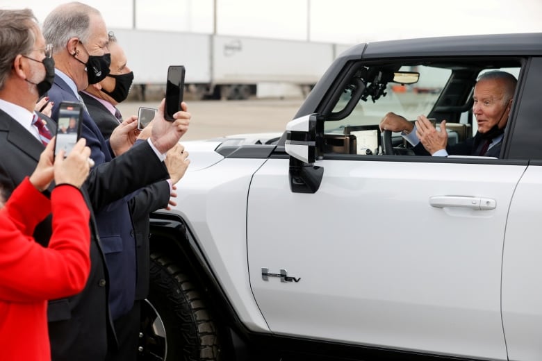 U.S. senators and representatives take pictures as President Joe Biden tests out a Hummer EV during a tour of the General Motors 'Factory ZERO' electric vehicle assembly plant in Detroit, Michigan on November 17, 2021.
