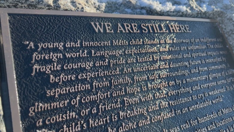 A bronze plaque describes the pain and suffering Metis and other Indigenous children went through at the Île-à-la-Crosse boarding school.
