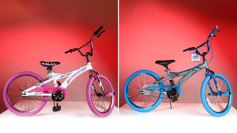 A pink, 20 inch bike with pink wheels and details is beside a blue bike with blue wheels. 