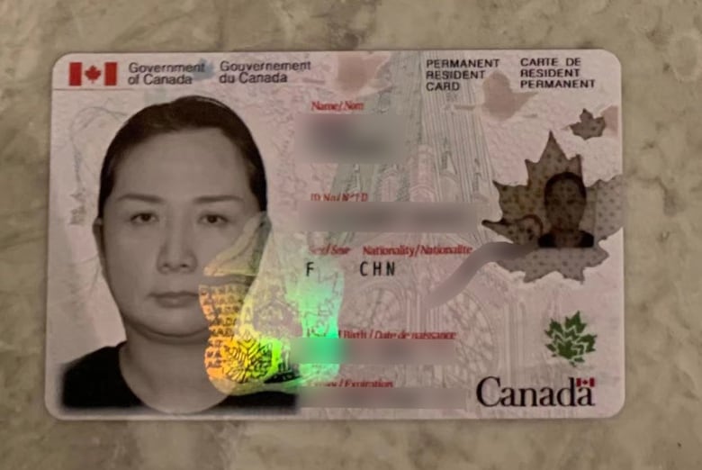 A snapshot of the fake permanent resident card used by one of the alleged fraudsters as proof of identity. It shows a photo on the left, and blurred out personal information on the right.