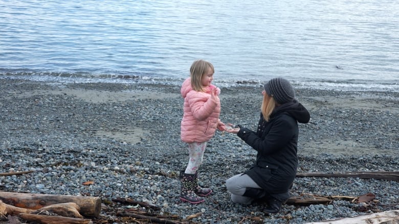A woman plays with her daughter by the seashore at Departure Bay beach.