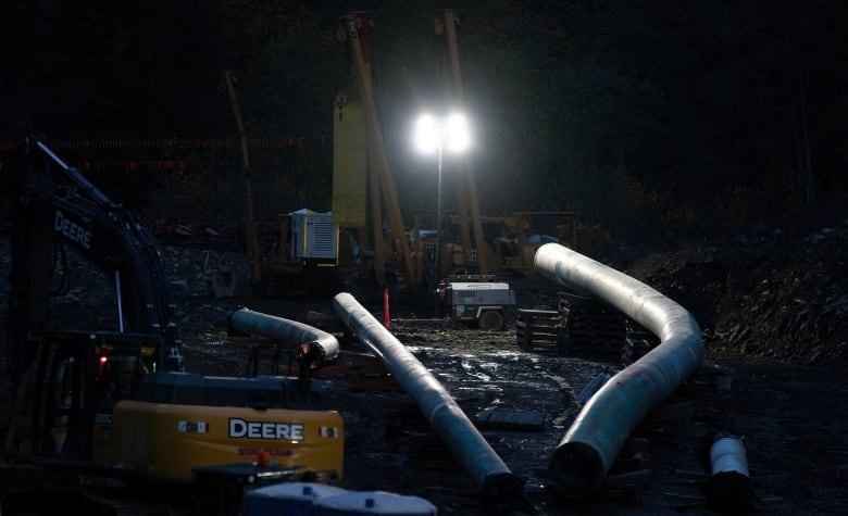 Heavy machinery moves pipelines during the night.