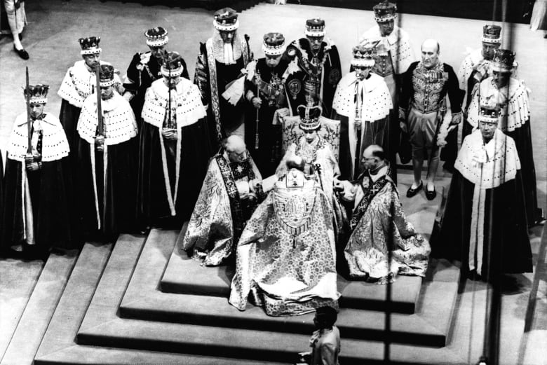 Queen Elizabeth II is seen seated on the throne during her coronation at Westminster Abbey in 1953.