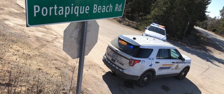 The road sign of Portapique Beach Road is shown next to an RCMP cruiser.