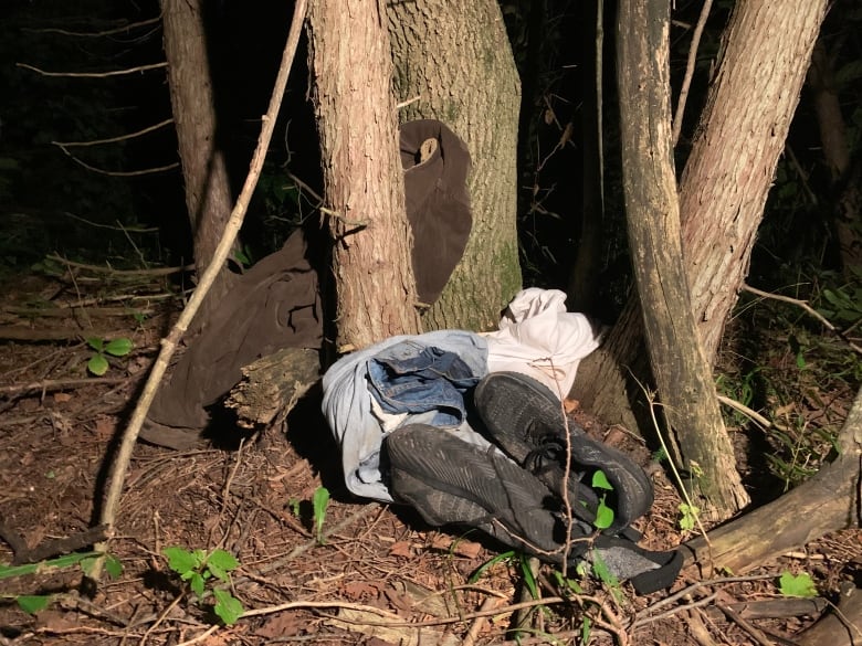 Wet, muddied clothes and shoes left behind in September 2022 by individuals crossing irregularly into the U.S. through forests along the Quebec-New York State border.