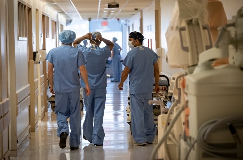 Surgical oncologists Dr. Usmaan Hameed, right, and Dr. Peter Stotland, left, walk to the operating room at North York General Hospital on May 26, 2020.