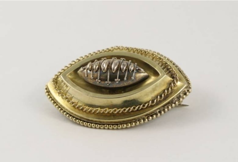 A small, delicate and ornate brooch. 