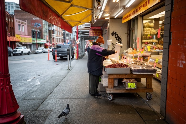 An elderly woman wearing a face mask to curb the spread of COVID-19 shops for dried goods at a store in Chinatown in Vancouver on January 27, 2021.