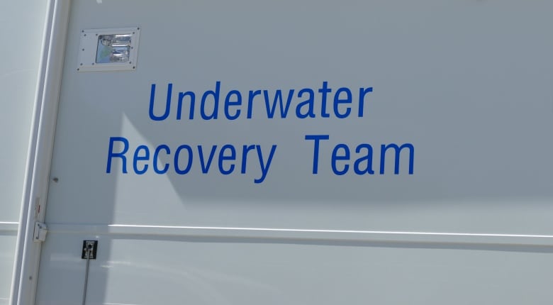 The words "underwater recovery team" are in blue letters on the side of a white vehicle.