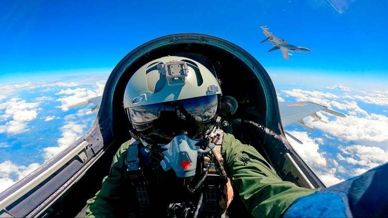 A jet fighter pilot in the cockpit.
