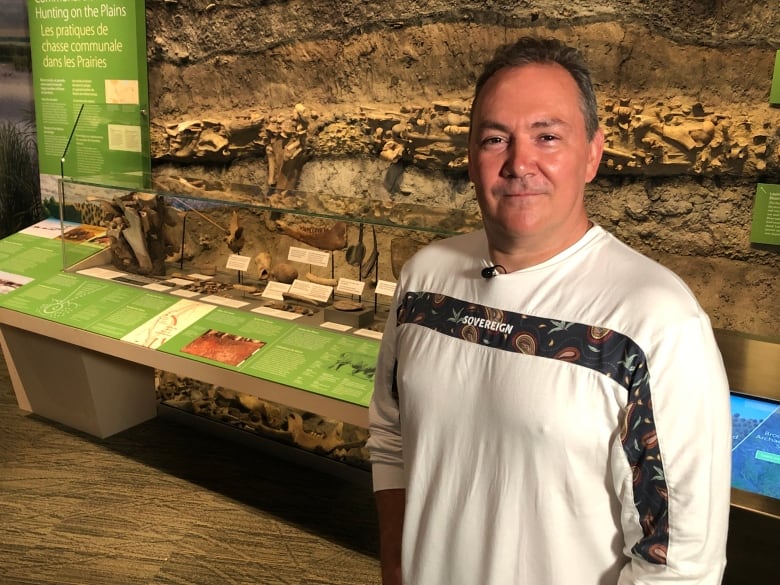 Kevin Brownlee stands in front of a museum display. 