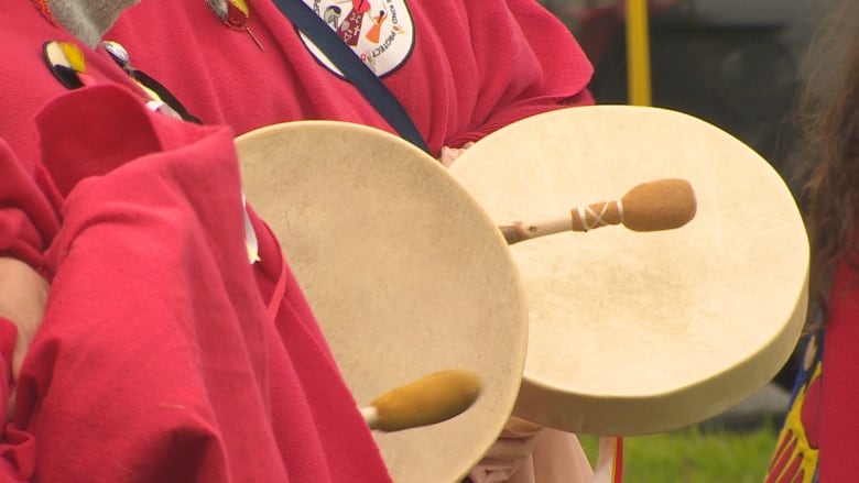 A close up of two hand-held drums being played.