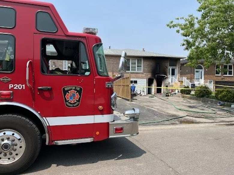 A firetruck seen outside of a home where a fatal fire killed one person and left two others including one child in life-threatening condition.