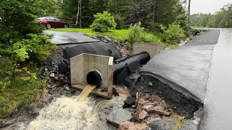 An exposed culvert at the end of a damaged driveway.