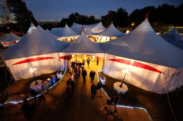 Theatre patrons walk in and out of the tents at Bard on the Beach. 