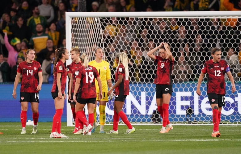 Women soccer players react after a goal.