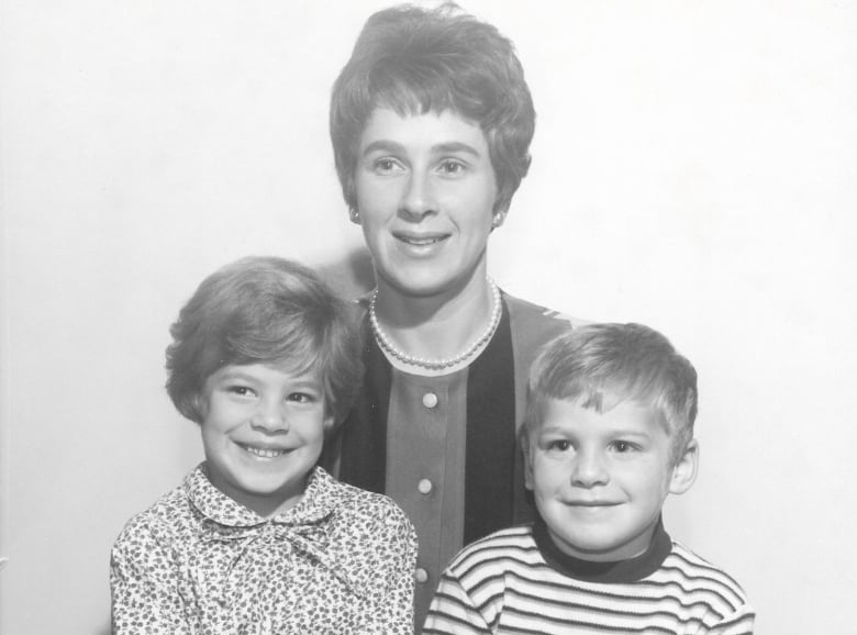 An old black-and-white family portrait of a mother with her two children