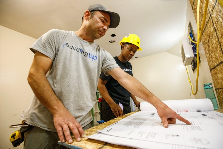 Tim Zubek, site supervisor with Building Up, and Dorine Khainza, an apprentice, are photographed inside of a Toronto home under construction on July 6, 2023.