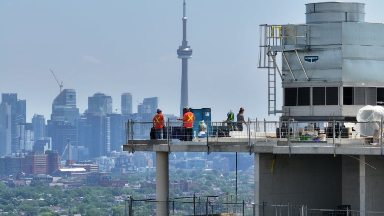 Construction workers are seen working on a condo building in Toronto, in early July 2023.