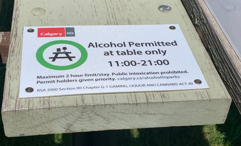 A sign that says 'alcohol permitted at table only 11:00 to 21:00'.