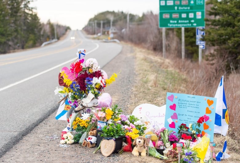 Flowers stuffed animals and homemade signs are seen along a Nova Scotia highway.