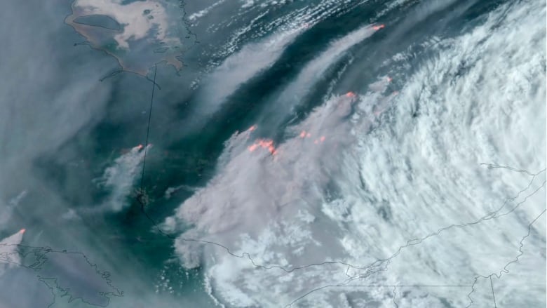 A satellite image shows several fires in Ontario and Quebec, with smoke drifting southward