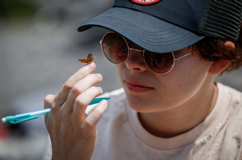A participant is visited by a moth while sketching the view of Upper Kananaskis Lake during the Rockies Journey camp run by Howl in Kananaskis.