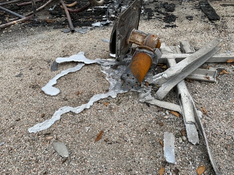 In Kasey DeMings' yard, a piece of ruined fishing gear shows how the heat of the fire caused metal gear to melt into a liquid state.