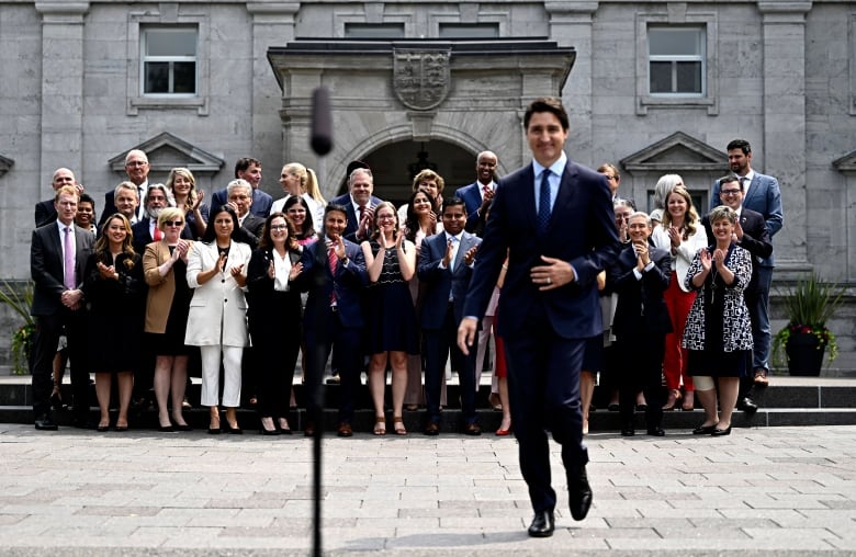 Justin Trudeau walks in front of his new cabinet