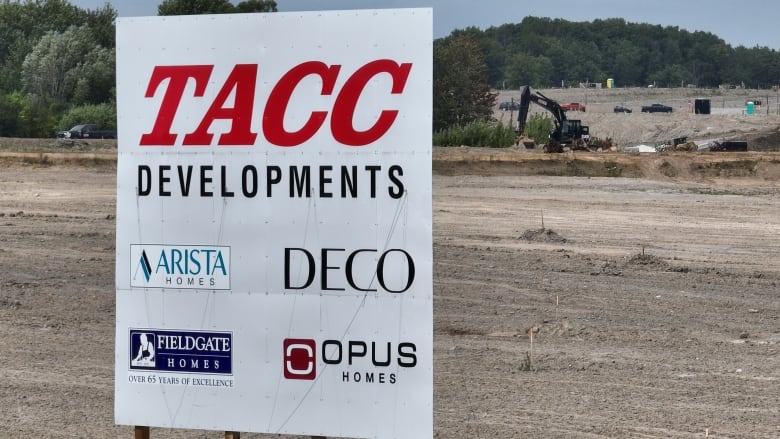 A sign with the logos of five construction companies is located on land currently under development.